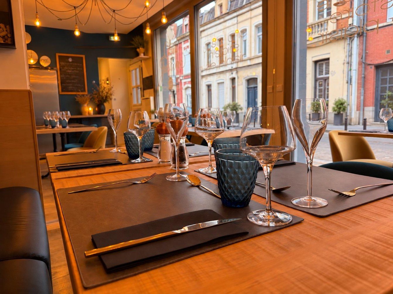 Salle du restaurant, tables dressées face aux grandes fenêtres